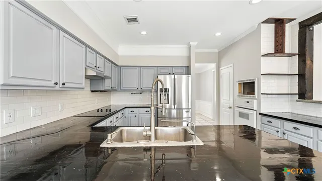 a kitchen with white cabinets and window