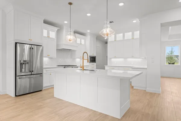 a kitchen with stainless steel appliances granite countertop a sink a refrigerator and a wooden floor