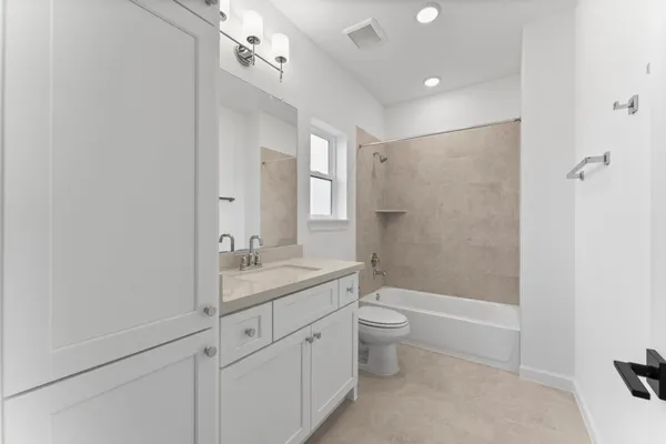 a bathroom with a granite countertop sink a toilet and shower