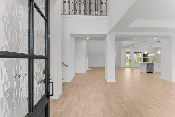 a view of a hallway with wooden floor and a bathroom