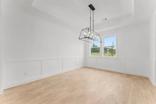 a view of an empty room with chandelier and window
