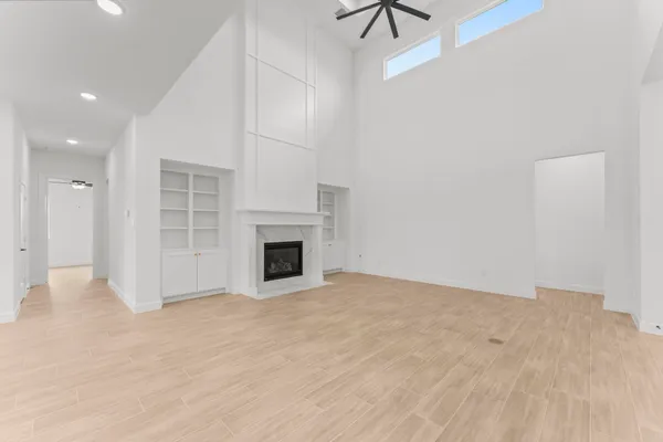 a view of empty room with wooden floor and fireplace