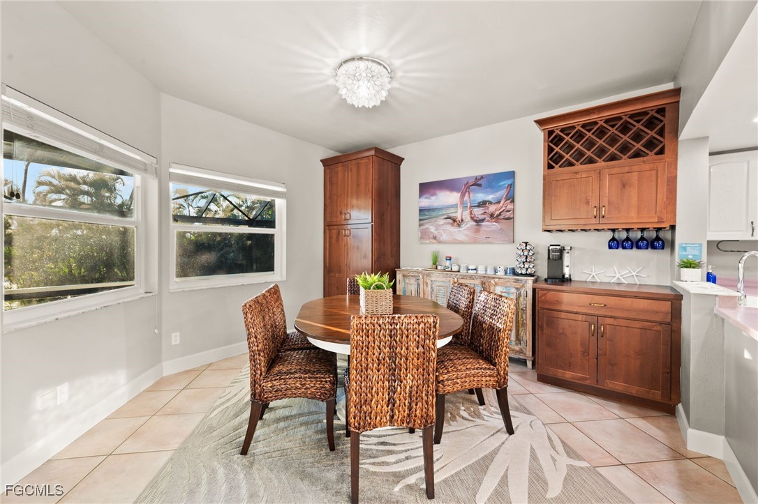 7507 Grande Pine Road Bokeelia, FL 33922 - Photo 17 of 46 a dining room with a wooden table and chairs