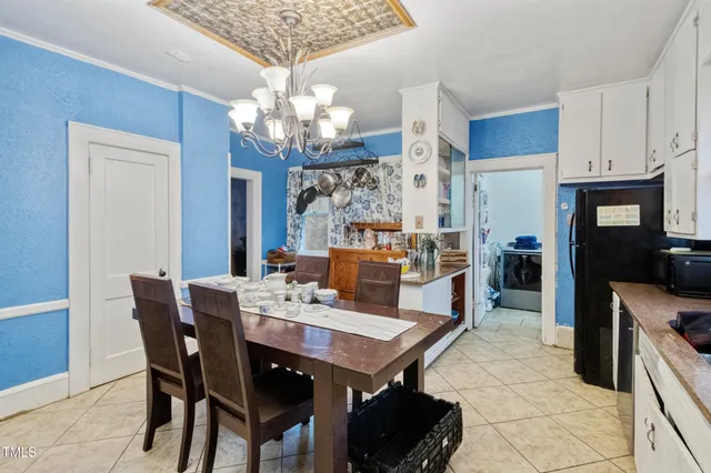 a kitchen with stainless steel appliances granite countertop a refrigerator a sink dishwasher a dining table and chairs with wooden floor