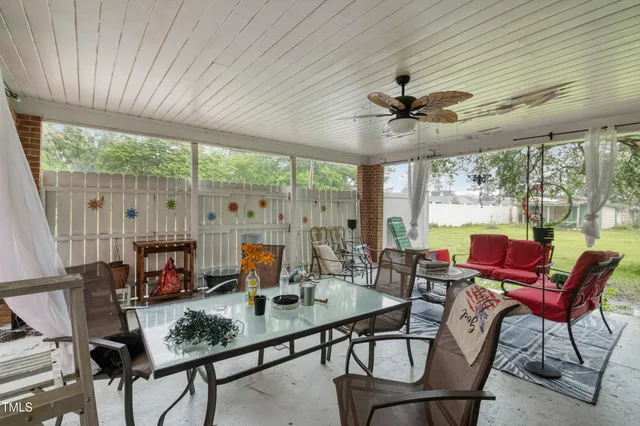 a living room with patio furniture and a floor to ceiling window