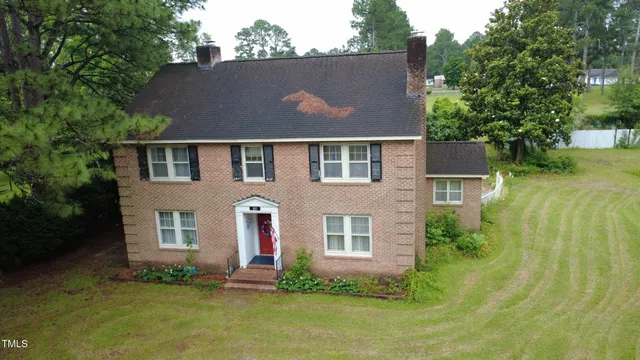 an aerial view of a house with swimming pool and garden