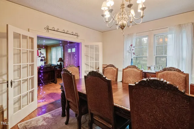 a living room with furniture a chandelier and a dining table
