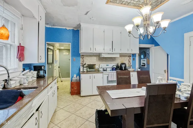 a living room with furniture a chandelier and large windows