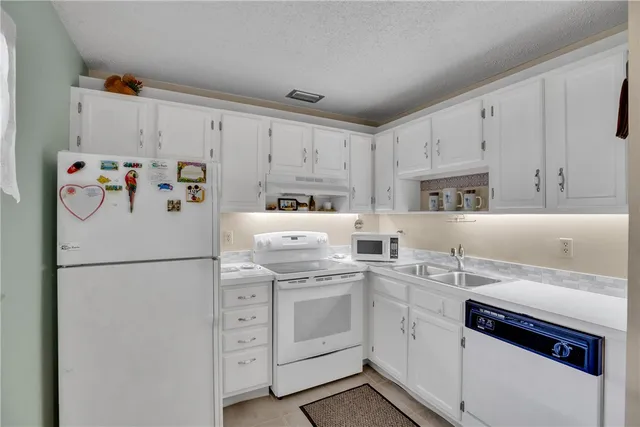a white refrigerator freezer sitting inside of a kitchen