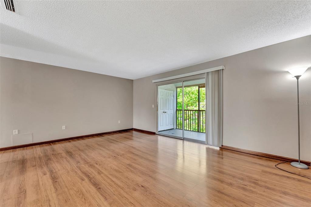13300 Walsingham Road, Unit 56 Largo, FL 33774 - Photo 11 of 35 a view of an empty room with wooden floor and a window