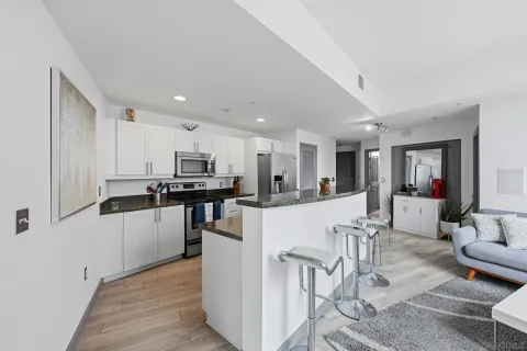 a kitchen with stainless steel appliances kitchen island granite countertop a refrigerator and a stove top oven