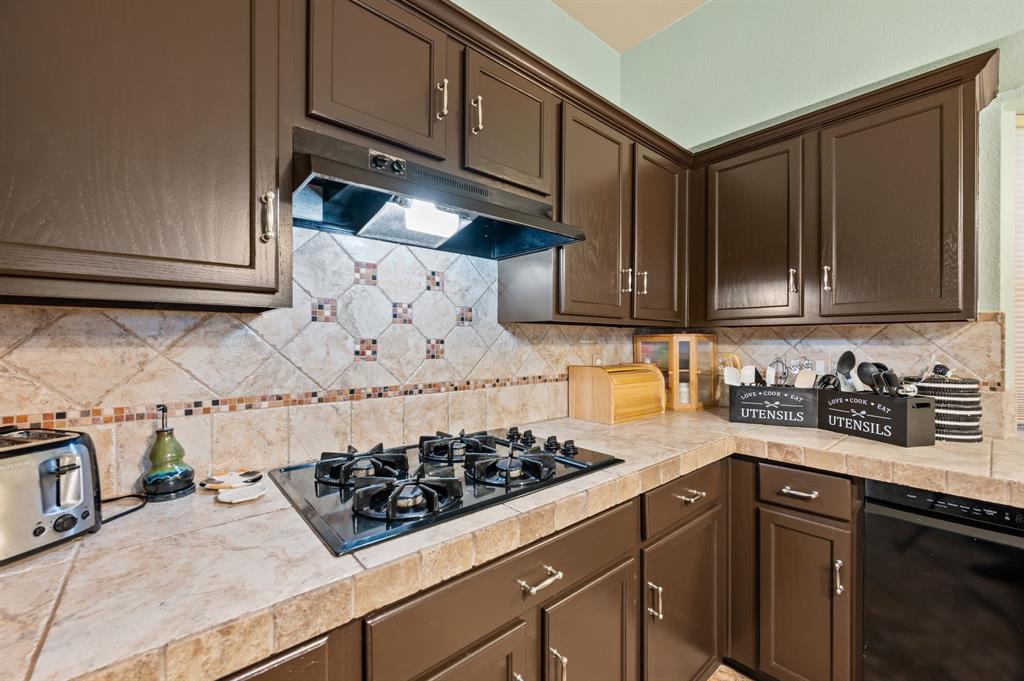 4008 Falcon Ridge Drive Haltom City, TX 76137 - Photo 13 of 32 a kitchen with wooden cabinets and a stove top oven