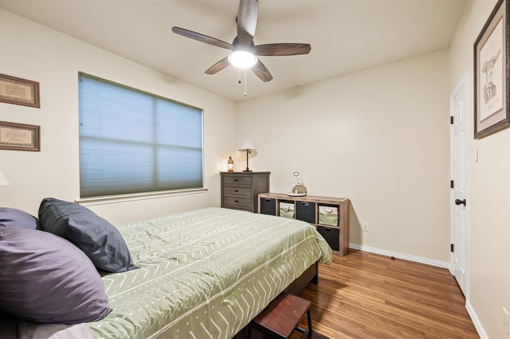 4008 Falcon Ridge Drive Haltom City, TX 76137 - Photo 15 of 32 a bedroom with a bed and a chandelier