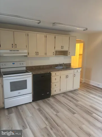 a kitchen with granite countertop a stove a sink and a cabinets