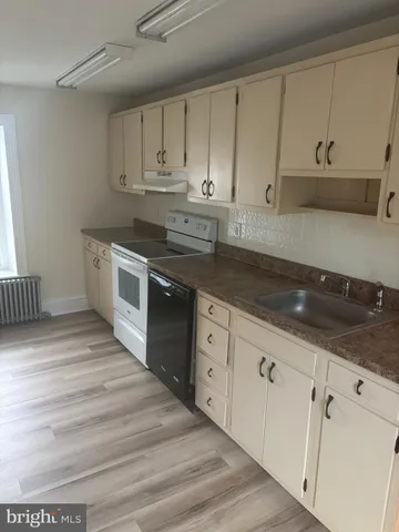 a kitchen with granite countertop white cabinets and white appliances