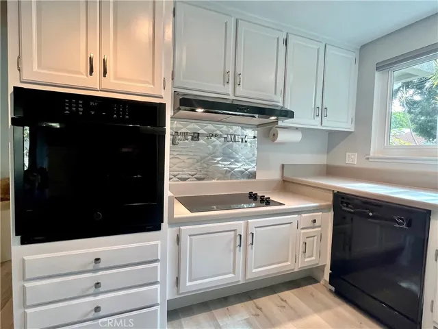 a kitchen with granite countertop white cabinets and sink