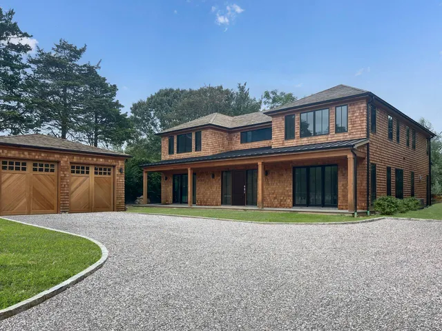 a front view of a house with a yard and trees