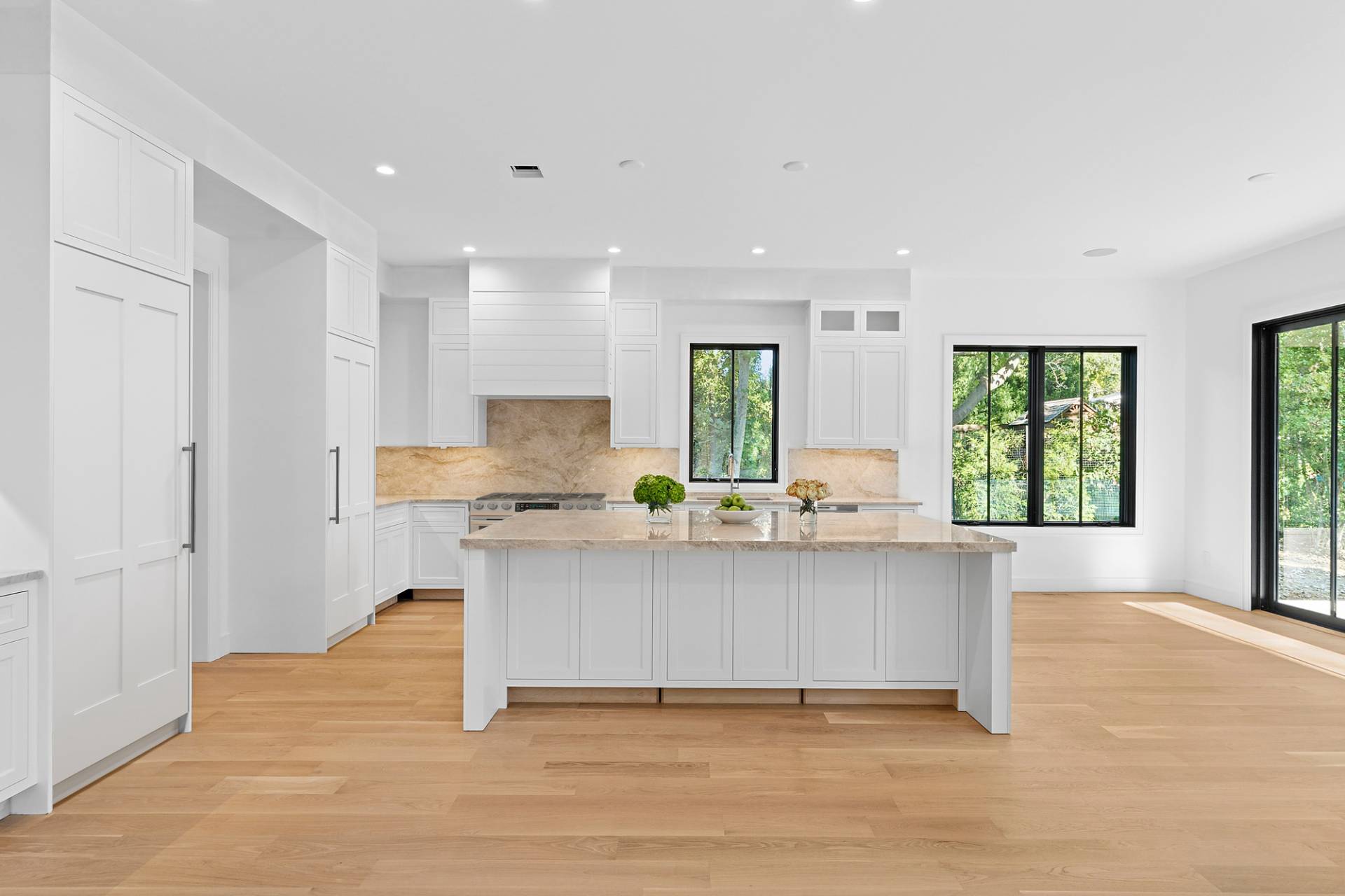 126 Long Lane East Hampton, NY 11937 - Photo 7 of 26 a large white kitchen with granite countertop a stove a sink a refrigerator and white cabinets with wooden floor