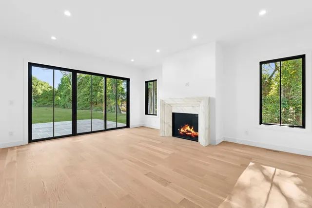 a view of an empty room with a fireplace and a window