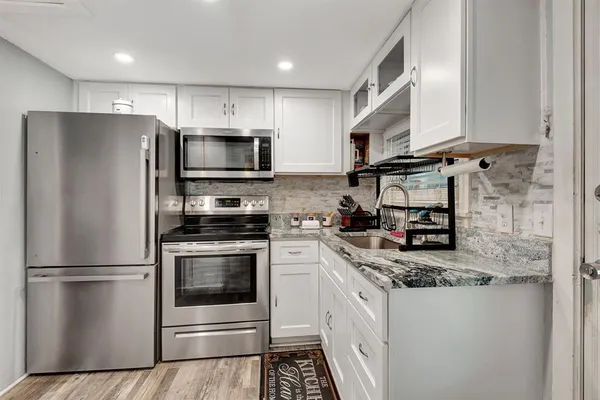 a kitchen with stainless steel appliances granite countertop a refrigerator sink and stove