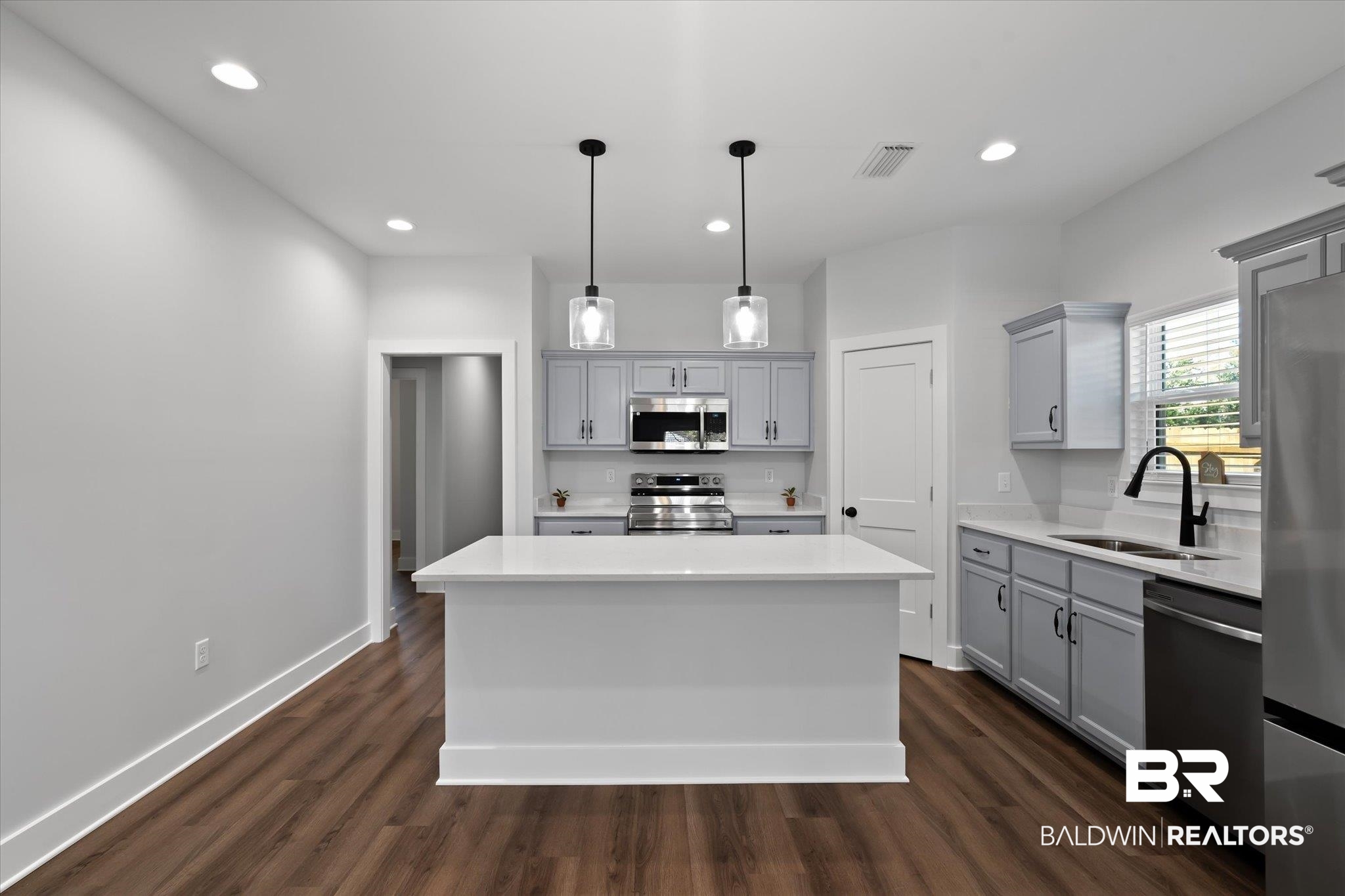18151 Hoiles Street Robertsdale, AL 36567 - Photo 7 of 23 Kitchen featuring appliances with stainless steel finishes, sink, decorative light fixtures, gray cabinetry, and a center island