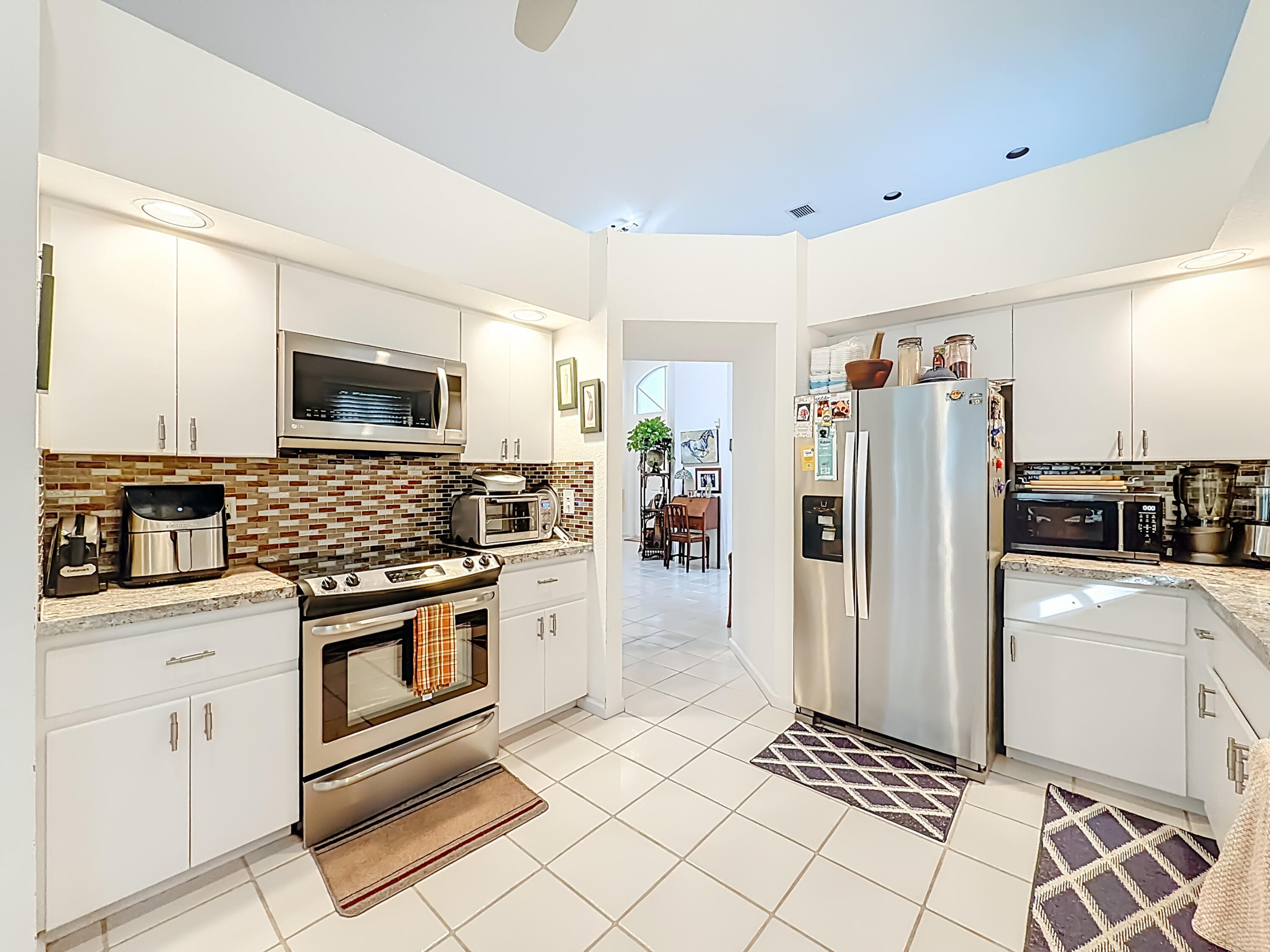 11853 Fountainside Circle Boynton Beach, FL 33437 - Photo 31 of 64 a kitchen with stainless steel appliances kitchen island granite countertop a refrigerator and a stove top oven