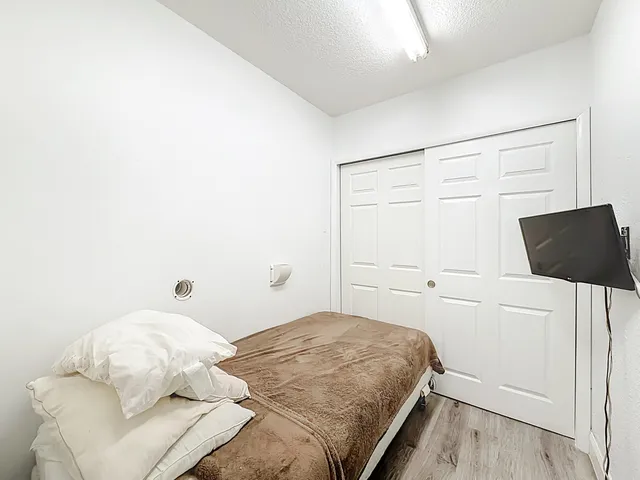 a view of a livingroom with wooden floor and white cabinet