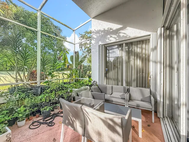 a view of a hallway to a livingroom with furniture and floor to ceiling window