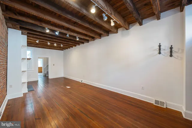 a view of empty room with wooden floor