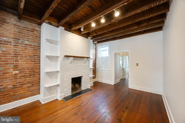 a view of empty room with wooden floor and fireplace