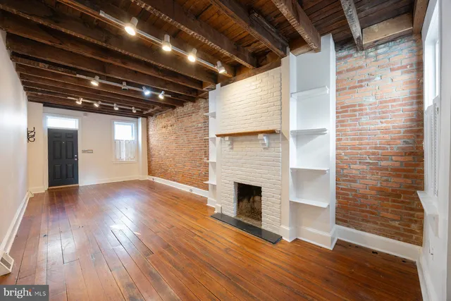 a view of empty room with wooden floor and fireplace