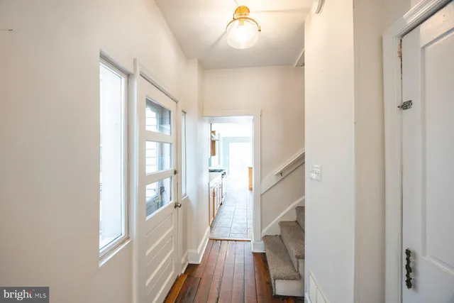 a view of a hallway with wooden floor and staircase