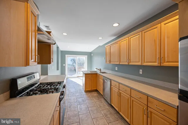 a kitchen with a sink a stove and cabinets