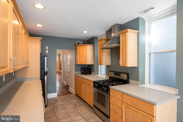 a kitchen with stainless steel appliances granite countertop a stove a sink and a refrigerator