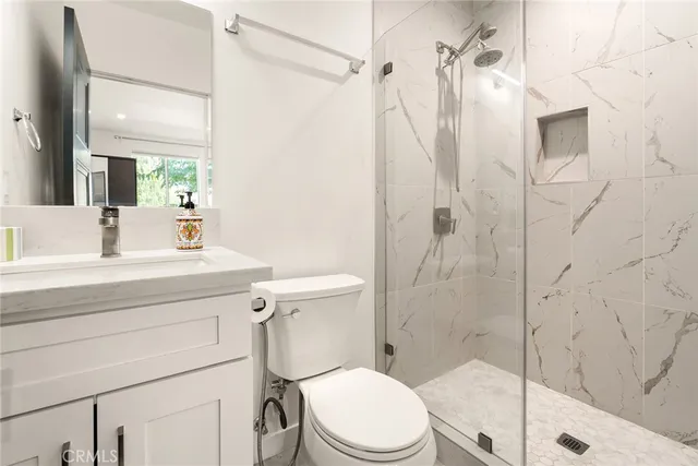 a bathroom with a sink a toilet and shower