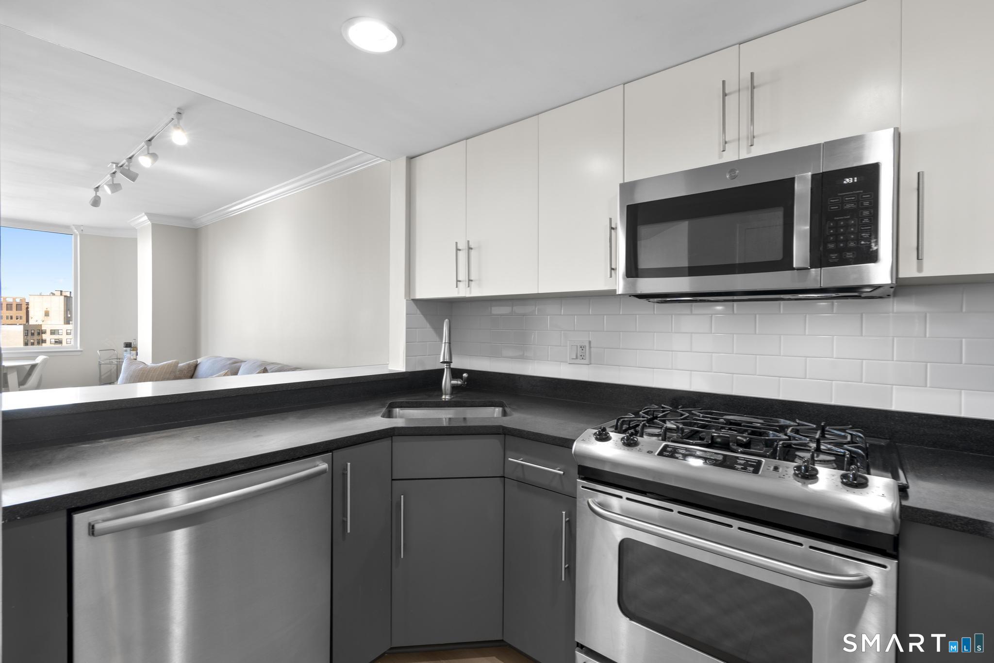 25 Forest Street, Unit 15E Stamford, CT 06901 - Photo 11 of 40 a kitchen with stainless steel appliances a stove a microwave and cabinets