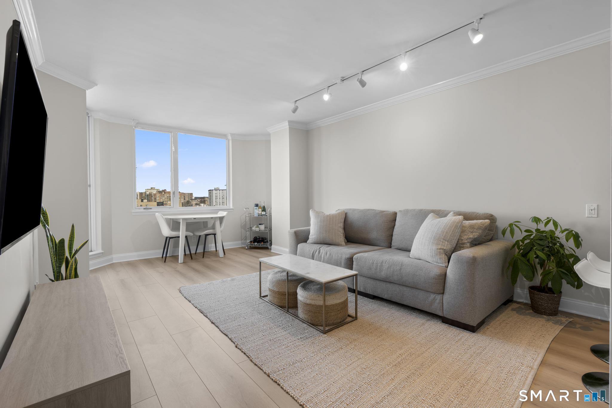 25 Forest Street, Unit 15E Stamford, CT 06901 - Photo 2 of 40 a living room with furniture and a flat screen tv