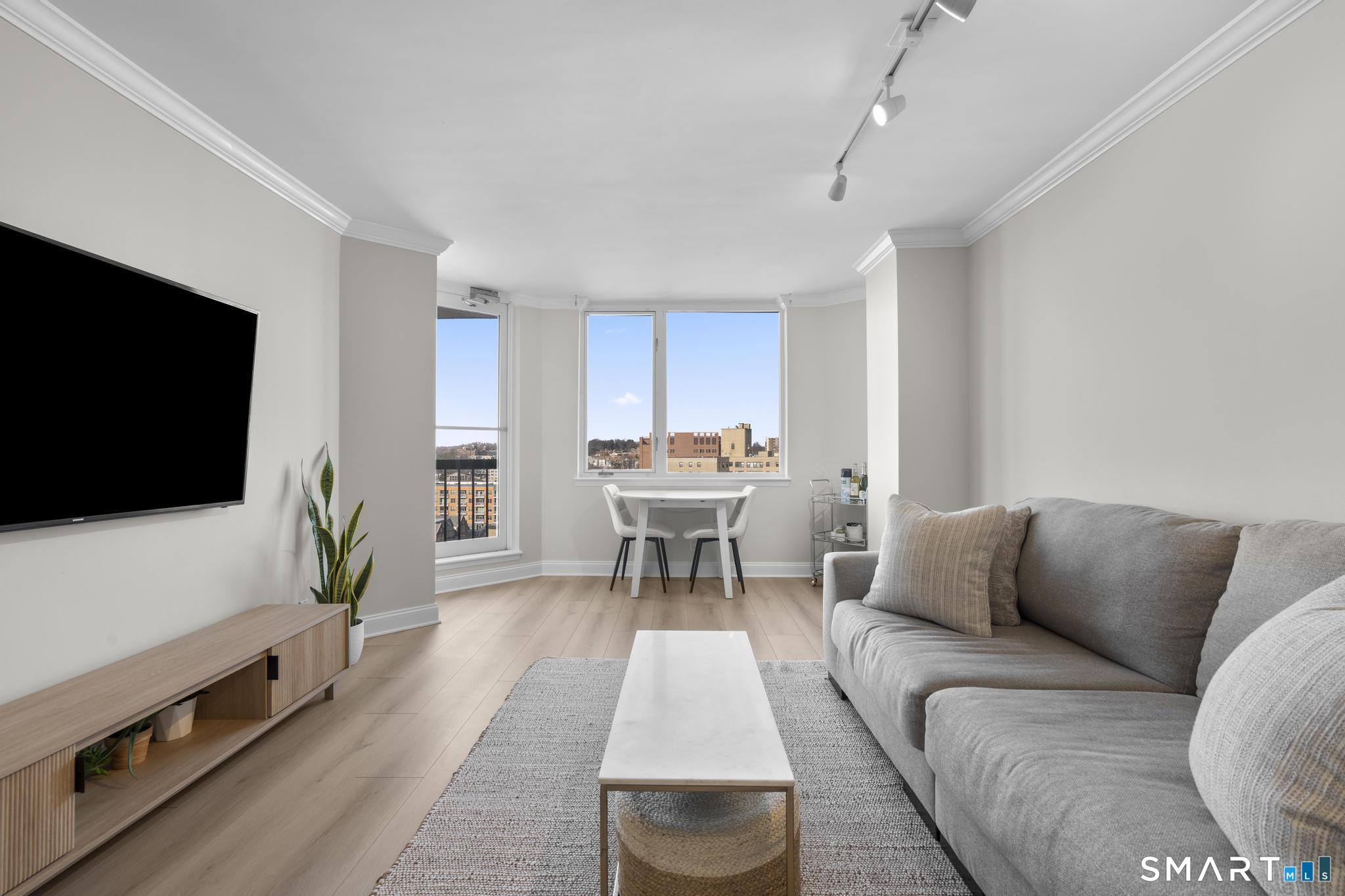 25 Forest Street, Unit 15E Stamford, CT 06901 - Photo 3 of 40 a living room with furniture and a flat screen tv
