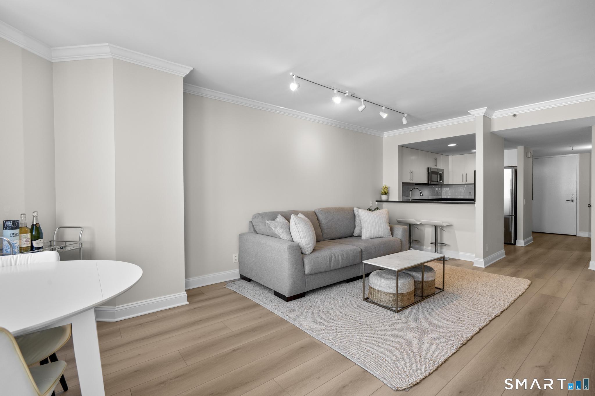 25 Forest Street, Unit 15E Stamford, CT 06901 - Photo 4 of 40 a living room with furniture and a wooden floor