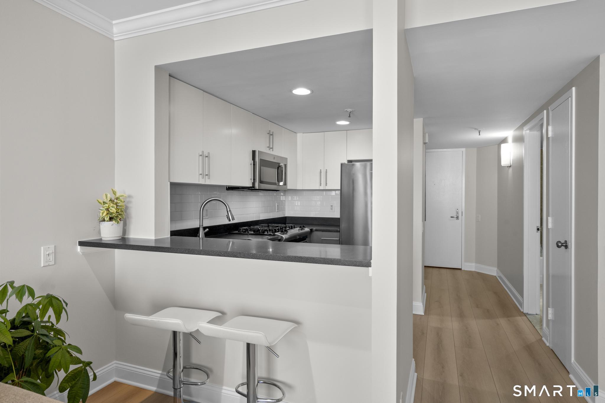 25 Forest Street, Unit 15E Stamford, CT 06901 - Photo 8 of 40 a kitchen with stainless steel appliances granite countertop a refrigerator and a stove top oven