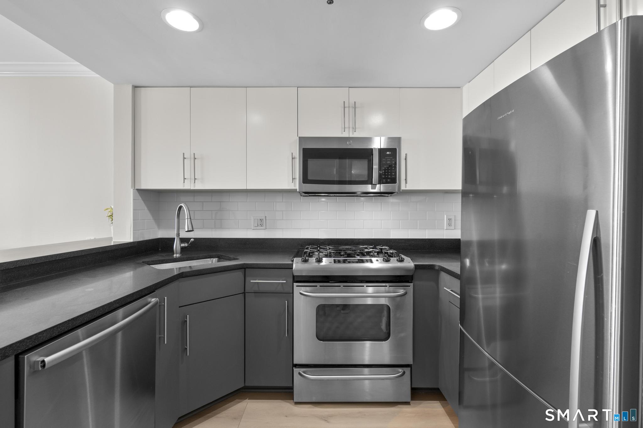 25 Forest Street, Unit 15E Stamford, CT 06901 - Photo 10 of 40 a kitchen with a sink stove and refrigerator