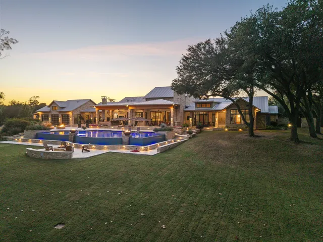 a view of a house with a big yard and sitting area