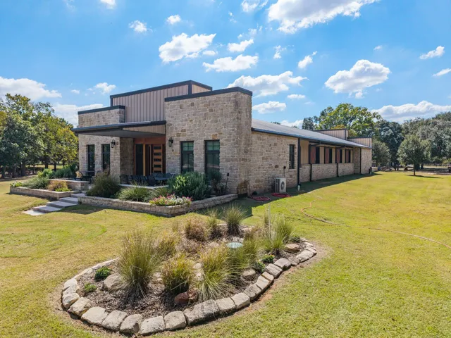 a large kitchen with stainless steel appliances granite countertop a stove oven a refrigerator a oven with white cabinets and wooden floor