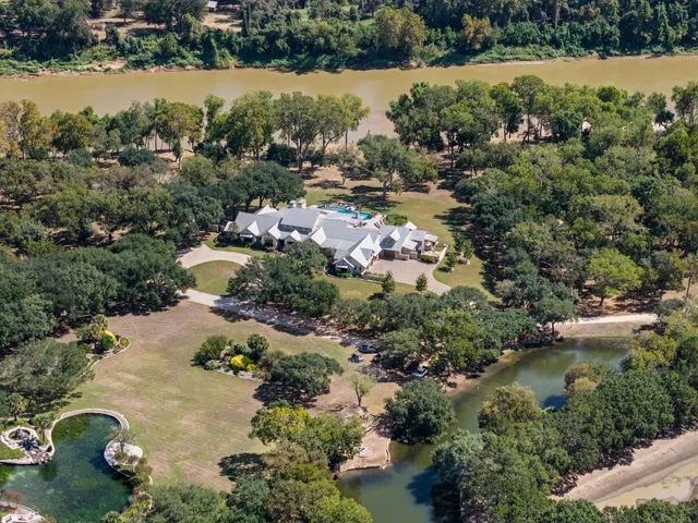 an aerial view of lake and residential houses with outdoor space