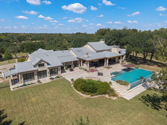 an aerial view of a house with swimming pool and mountain view