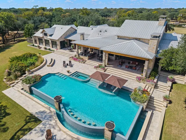 an aerial view of a house with pool patio and outdoor seating