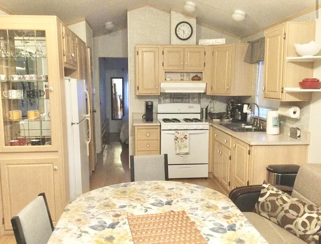74711 Dillon Road Desert Hot Springs, CA 92241 - Photo 6 of 41 a kitchen with stainless steel appliances kitchen island granite countertop a refrigerator a stove a sink dishwasher and white cabinets with wooden floor