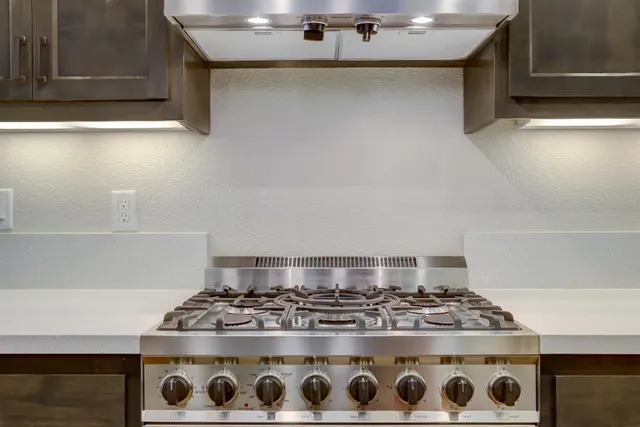 a kitchen with stainless steel appliances granite countertop a stove and a wooden floors