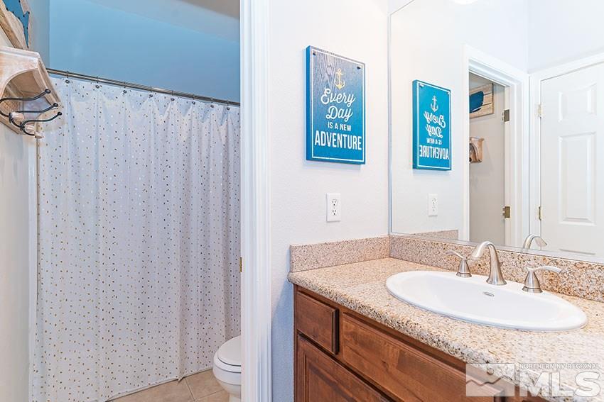 2895 Bryan Street Reno, NV 89503 - Photo 15 of 17 a bathroom with a granite countertop sink a toilet and a mirror