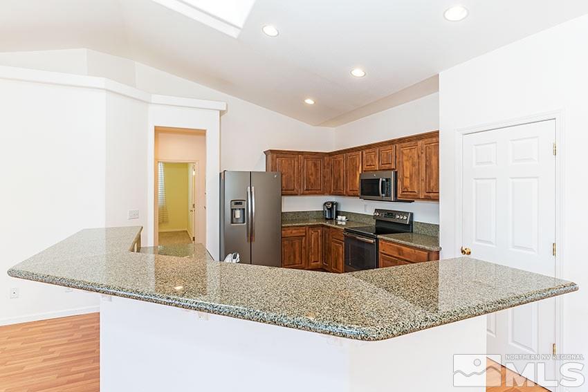 2895 Bryan Street Reno, NV 89503 - Photo 8 of 17 a kitchen with stainless steel appliances granite countertop a sink a stove and a refrigerator